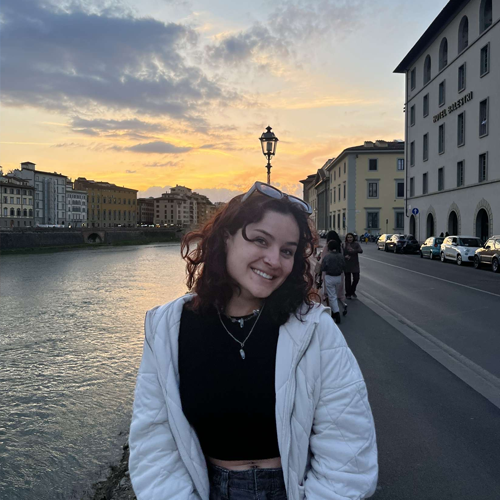 Student sitting on the banks of the Arno River in Florence